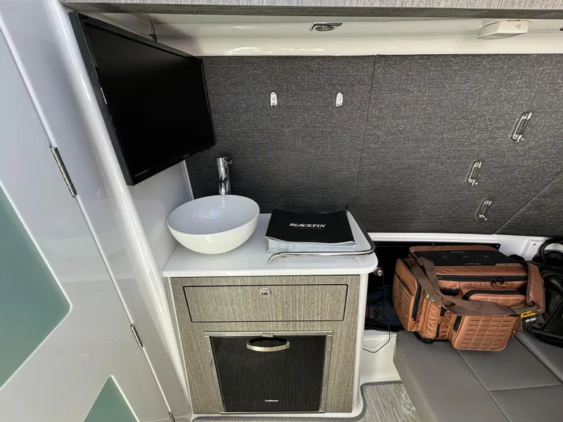Slide: The Image of 2025 Blackfin 400 CC interior with sink, TV, and storage. - 5