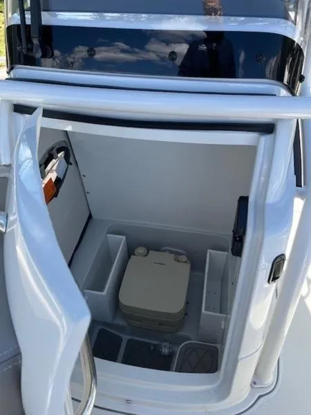 Slide: The Image of 2024 Finseeker 230 boat storage compartment with portable toilet and organized spaces. - 6