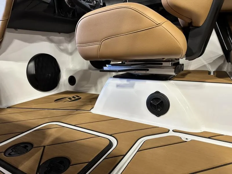 Slide: The Image of 2024 Malibu 22 LSV boat interior with tan seats and teak flooring. - 11