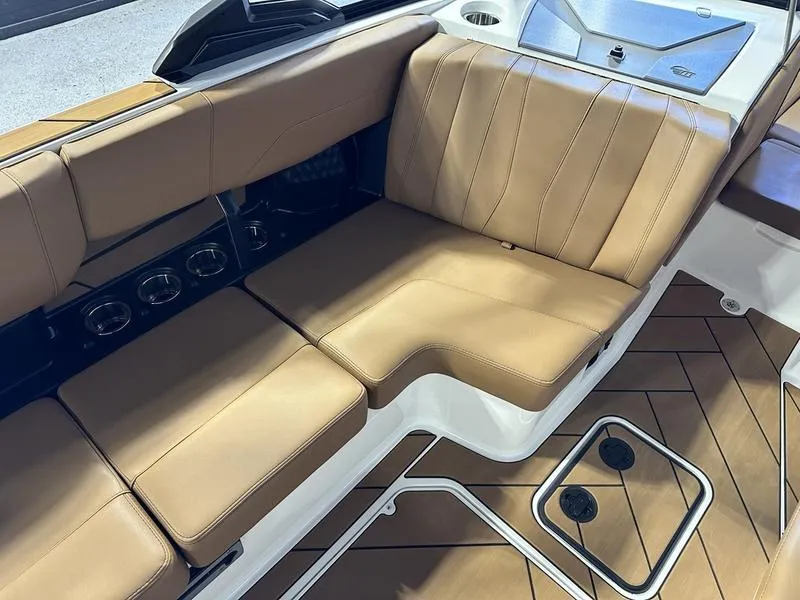 Slide: The Image of 2024 Malibu 22 LSV boat interior with tan leather seating and cup holders. - 12