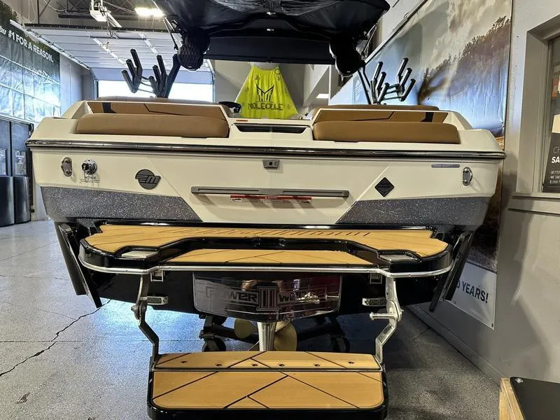 Slide: The Image of 2024 Malibu 22 LSV boat rear view in showroom with teak swim platform. - 4