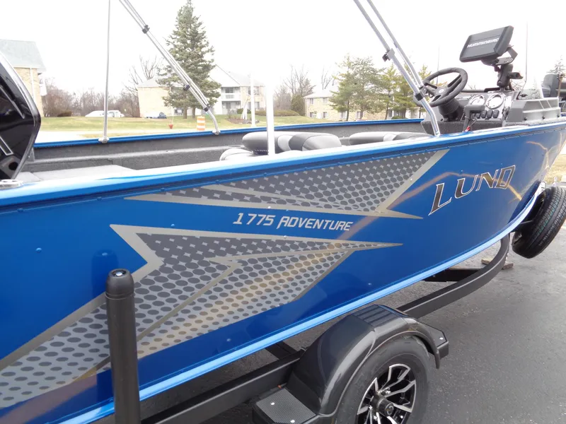 Slide: The Image of 2024 Lund 1775 Adventure SS boat, blue exterior, parked on trailer. - 4