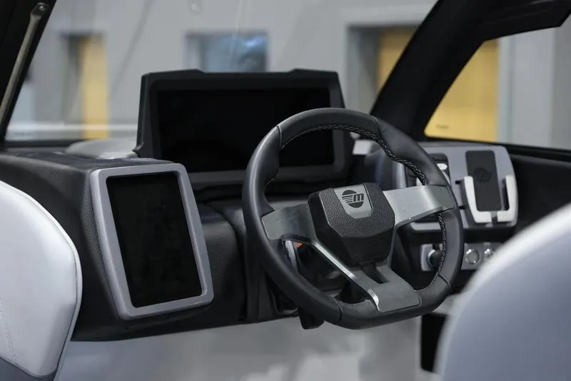 Slide: The Image of 2024 Malibu 23 LSV boat dashboard with modern steering wheel and digital displays. - 11