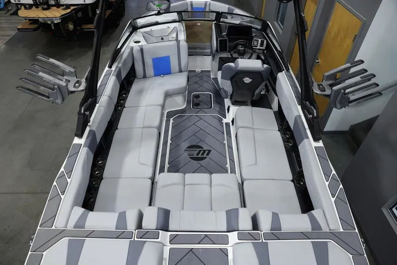 Slide: The Image of 2024 Malibu 23 LSV boat interior with gray and white seating, advanced dashboard, and spacious layout. - 8