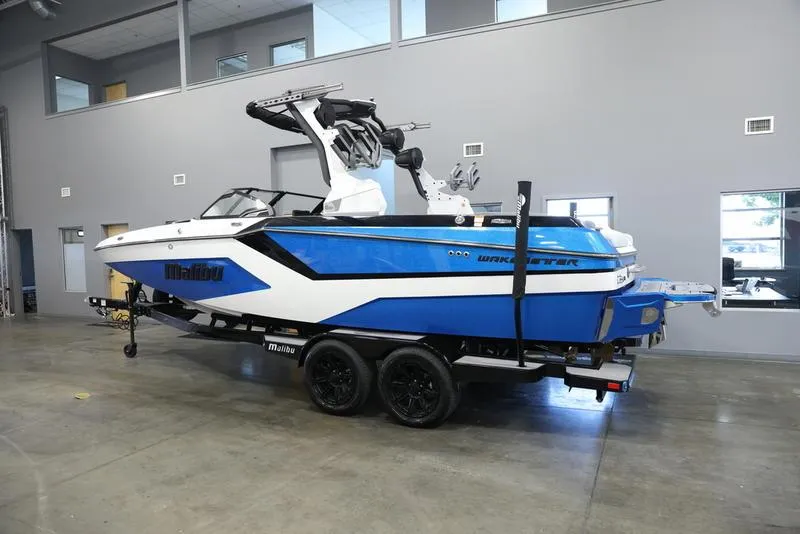 Slide: The Image of 2024 Malibu 23 MXZ wakeboard boat in showroom. - 1
