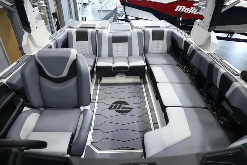 Slide: The Image of 2024 Malibu 23 MXZ boat interior with gray and white seating. - 17