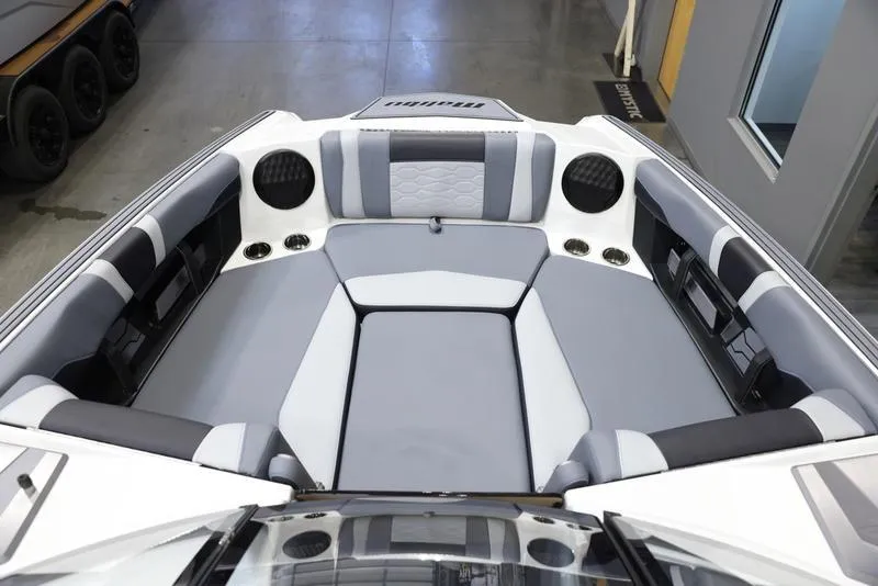 Slide: The Image of 2024 Malibu 23 MXZ boat interior with gray and white seating. - 18