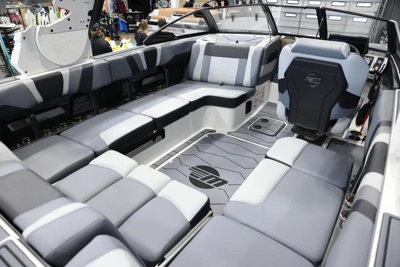 Slide: The Image of 2024 Malibu 23 MXZ boat interior with gray and white seating. - 21