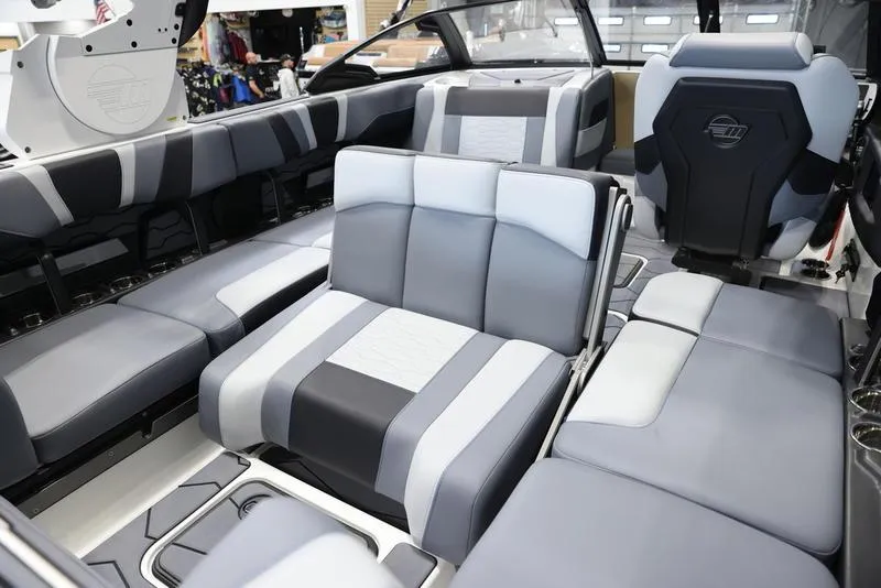 Slide: The Image of 2024 Malibu 23 MXZ boat interior with gray and white seating. - 23