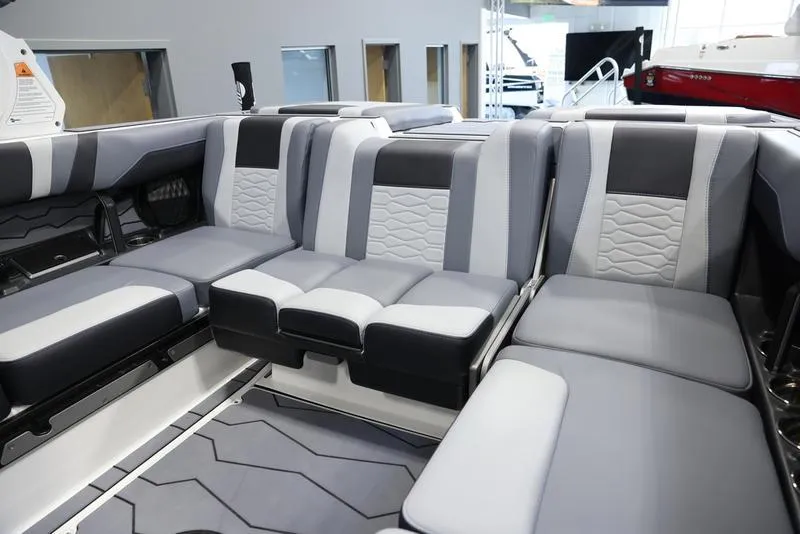 Slide: The Image of 2024 Malibu 23 MXZ boat interior with gray and black cushioned seating. - 25
