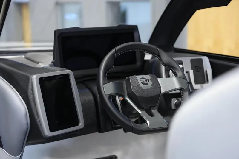 Slide: The Image of 2024 Malibu 23 MXZ boat dashboard with modern steering wheel and digital displays. - 4