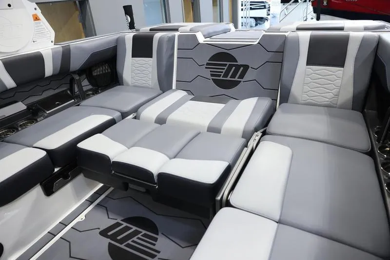 Slide: The Image of 2024 Malibu 23 MXZ boat interior with gray and white cushioned seating. - 6