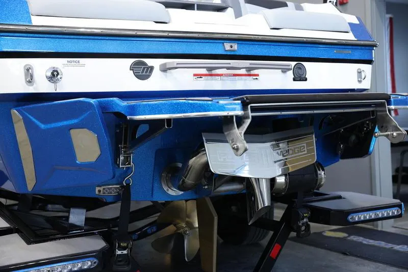 Slide: The Image of 2024 Malibu 23 MXZ boat rear view, showcasing propeller and wakeboard features. - 9