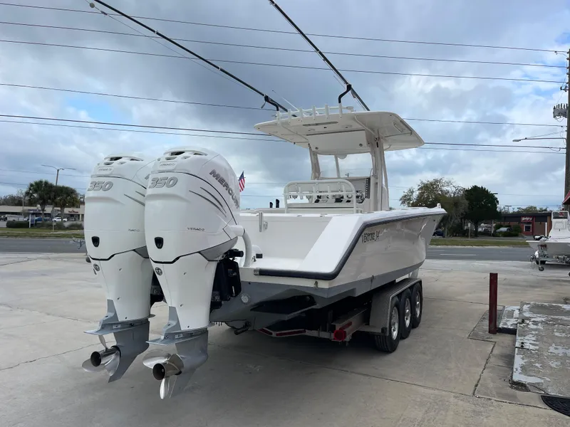 Slide: The Image of 1999 Venture 34 Center Console boat with twin outboard engines on a trailer. - 3
