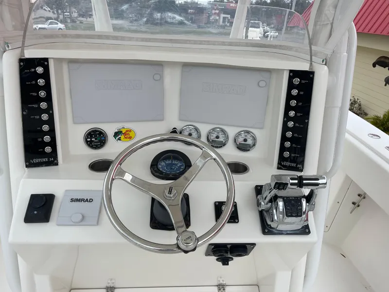 Slide: The Image of 1999 Venture 34 Center Console boat helm with steering wheel and navigation instruments. - 6