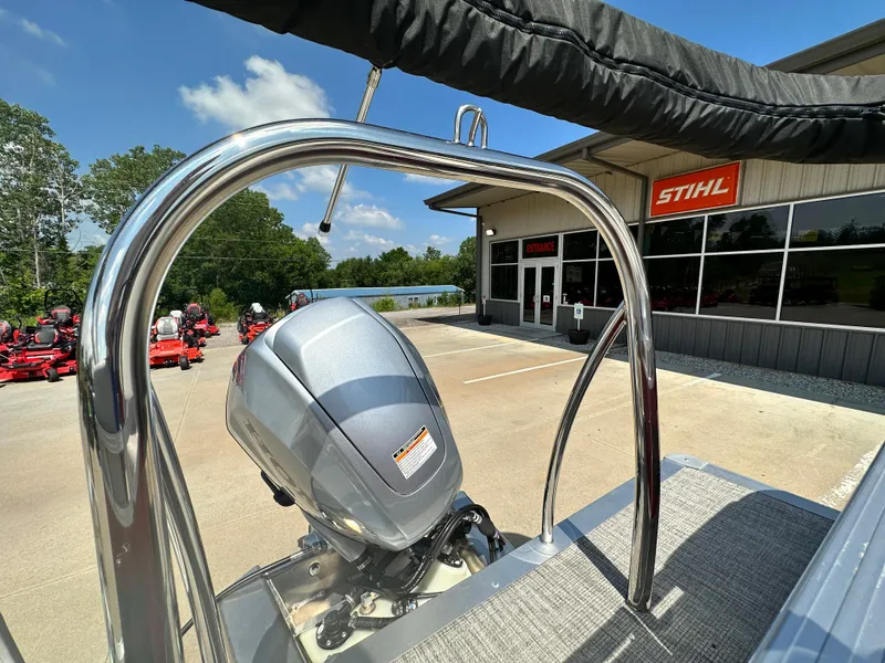 Slide: The Image of 2023 Tahoe Pontoon SLT Quad Lounge boat with motor, parked outside a Stihl dealership. - 11