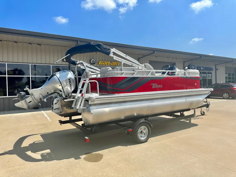Slide: The Image of 2023 Tahoe Pontoon SLT Quad Lounge on trailer, red and silver, parked outside. - 3
