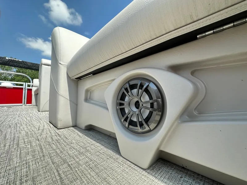 Slide: The Image of 2023 Tahoe Pontoon SLT Quad Lounge interior with speaker and cushioned seating. - 7