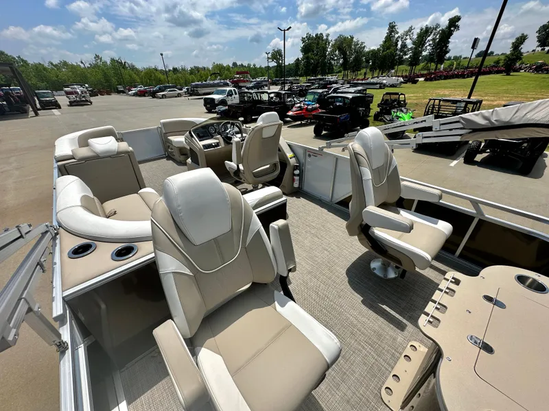 Slide: The Image of 2023 Tahoe Pontoon LTZ Rear Fish boat with beige seating, parked outdoors. - 18