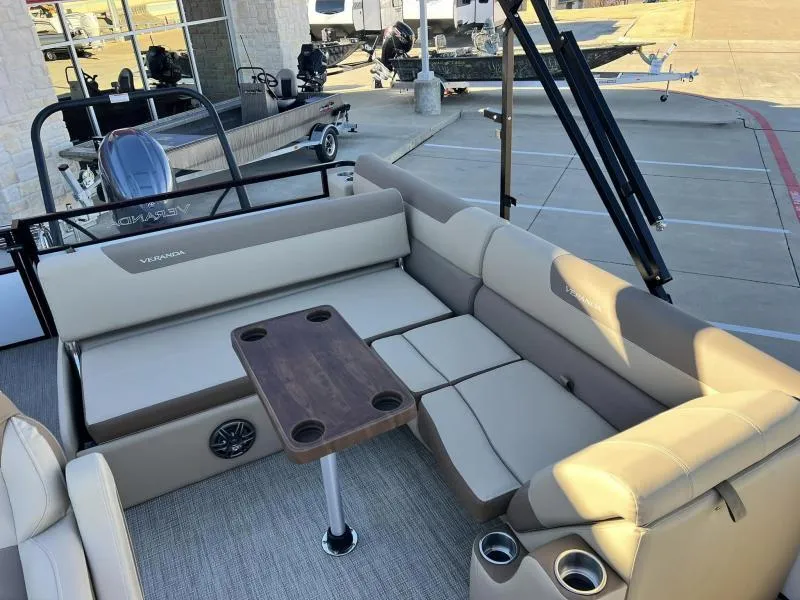 Slide: The Image of 2024 Veranda VR22VLB pontoon boat interior with beige seating and wooden table. - 10
