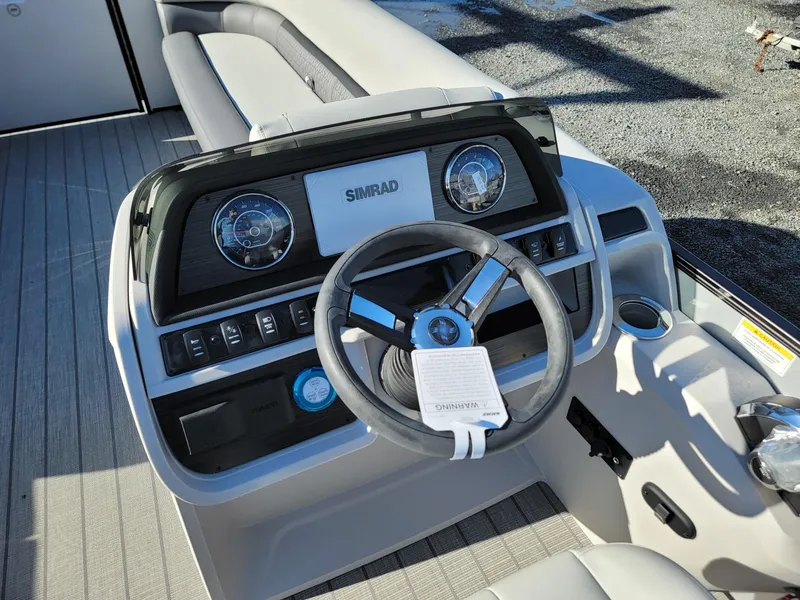 Slide: The Image of 2024 Godfrey SWEETWATER 2286 SFL boat dashboard with steering wheel and Simrad display. - 13