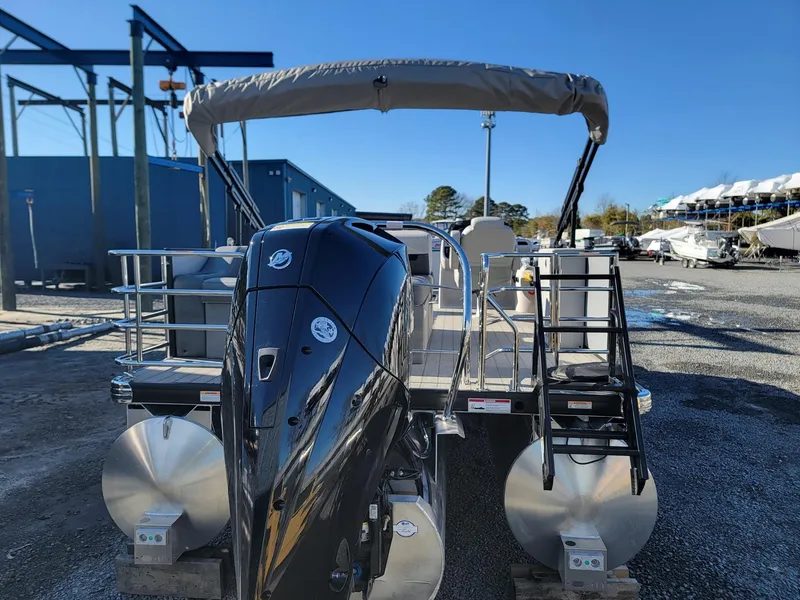Slide: The Image of 2024 Godfrey SWEETWATER 2286 SFL pontoon boat with outboard motor, docked at a marina. - 3