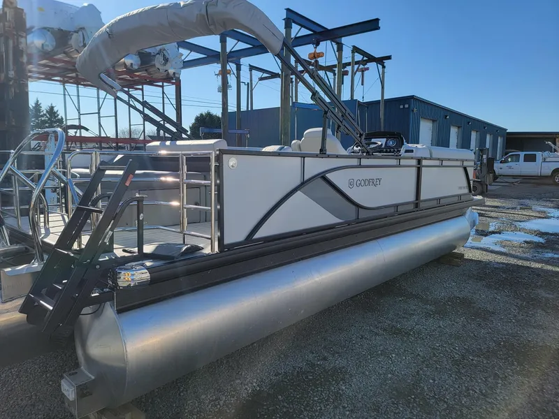Slide: The Image of 2024 Godfrey SWEETWATER 2286 SFL pontoon boat in a marina. - 4