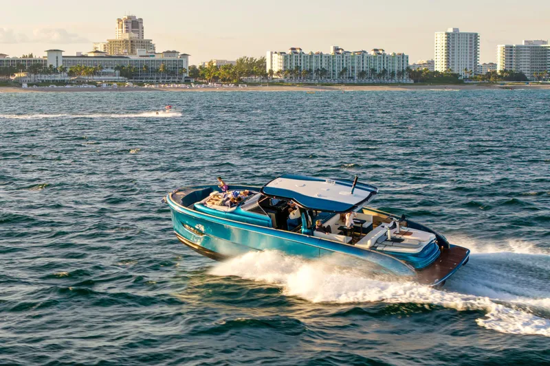 Slide: The Image of 2024 Solaris Power 52 Open yacht cruising near a coastal city skyline. - 45