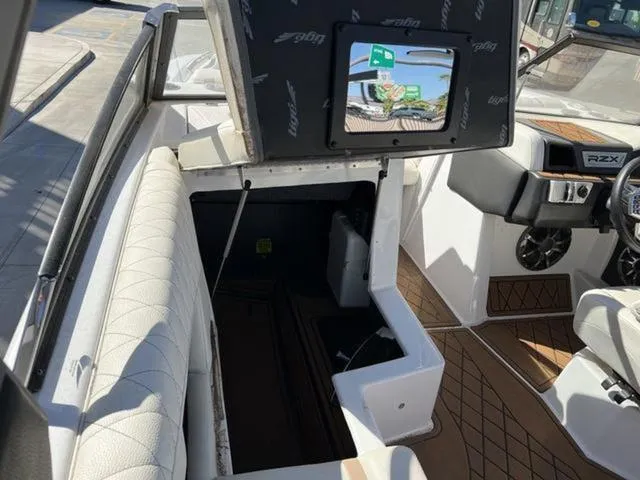 Slide: The Image of 2019 Tigé RZX2 boat interior with open storage compartment and dashboard view. - 12