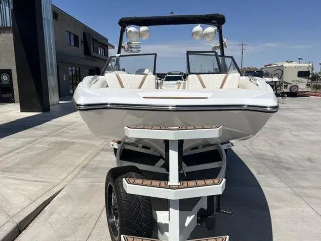 Slide: The Image of 2019 Tigé RZX2 boat on trailer, front view, parked outdoors. - 19