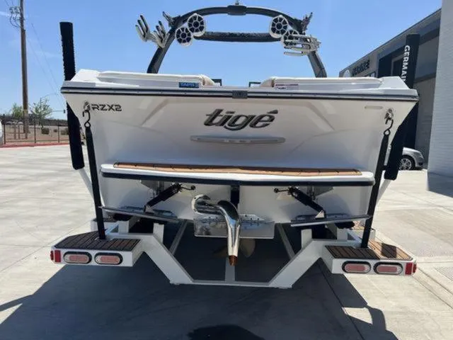 Slide: The Image of 2019 Tigé RZX2 boat rear view, parked outdoors, showcasing wakeboard tower and swim platform. - 21