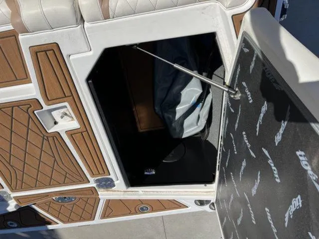Slide: The Image of 2019 Tigé RZX2 boat storage compartment with open hatch and interior view. - 31