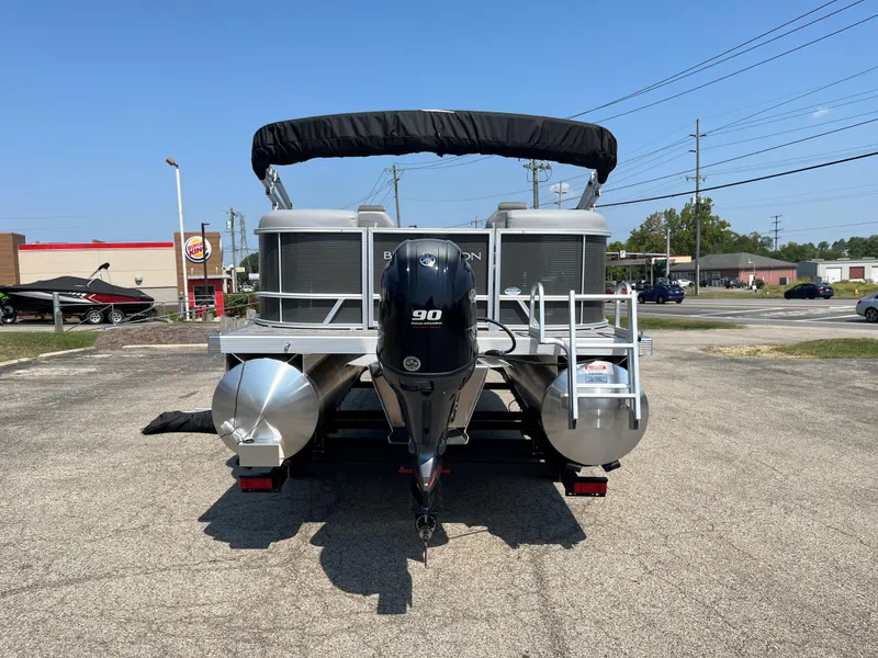 Slide: The Image of 2024 Bennington SV Line pontoon boat with 90 HP motor, parked outdoors. - 11