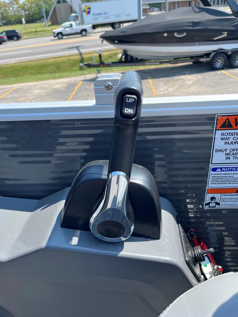 Slide: The Image of 2024 Bennington SV Line boat throttle control lever in a marina setting. - 6