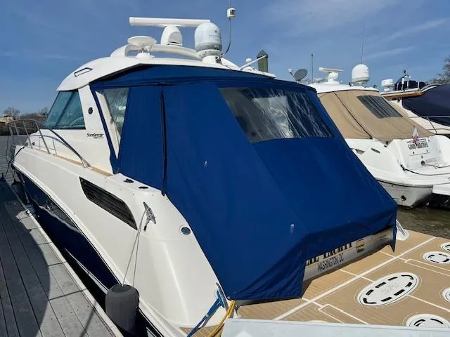 Slide: The Image of 2010 Sea Ray 450 Sundancer yacht docked with blue canvas cover. - 2