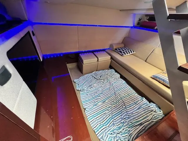 Slide: The Image of Interior of 2010 Sea Ray 450 Sundancer with cozy seating and striped blanket. - 23