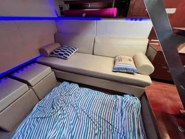 Slide: The Image of Interior of 2010 Sea Ray 450 Sundancer with beige sofa and striped bedding. - 24