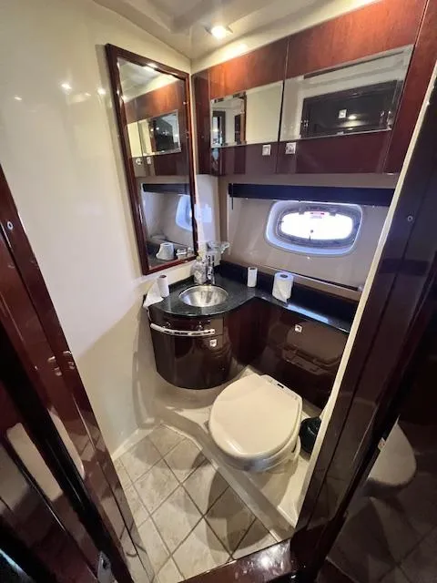 Slide: The Image of 2010 Sea Ray 450 Sundancer yacht bathroom with modern fixtures and porthole window. - 28