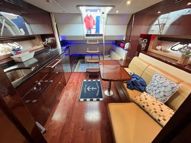 Slide: The Image of Interior of 2010 Sea Ray 450 Sundancer yacht with modern kitchen and cozy seating area. - 32