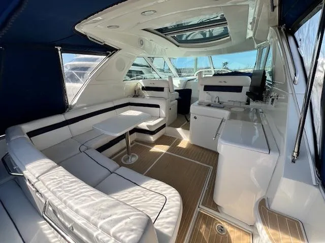 Slide: The Image of 2010 Sea Ray 450 Sundancer interior with white seating, table, and helm station. - 7