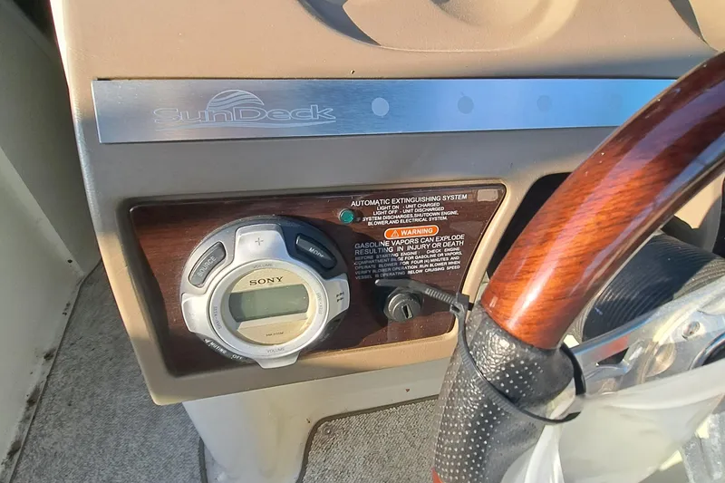 Slide: The Image of Sea Ray 260 Sun Deck 2010 dashboard with Sony stereo and wooden steering wheel. - 11