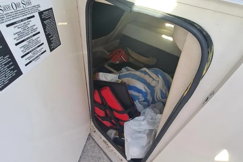 Slide: The Image of Storage compartment of a 2010 Sea Ray 260 Sun Deck boat with life jacket and towel. - 21