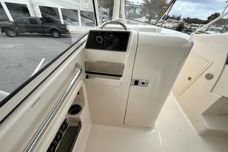 Slide: The Image of 2023 Grady-White Freedom 275 boat interior with control panel and storage compartment. - 11