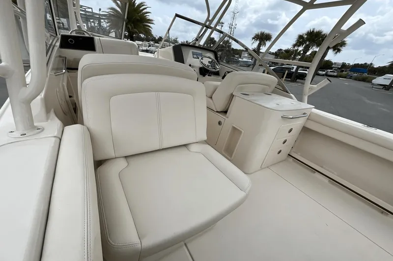 Slide: The Image of 2023 Grady-White Freedom 275 boat interior with white seating and helm station. - 19