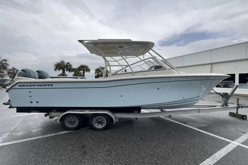 Slide: The Image of 2023 Grady-White Freedom 275 boat on trailer, parked outdoors. - 2