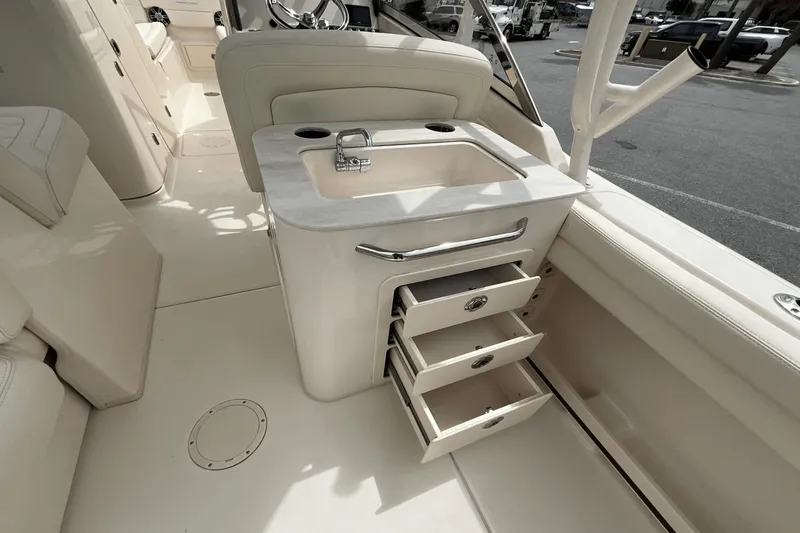 Slide: The Image of 2023 Grady-White Freedom 275 boat interior with sink and open storage drawers. - 22
