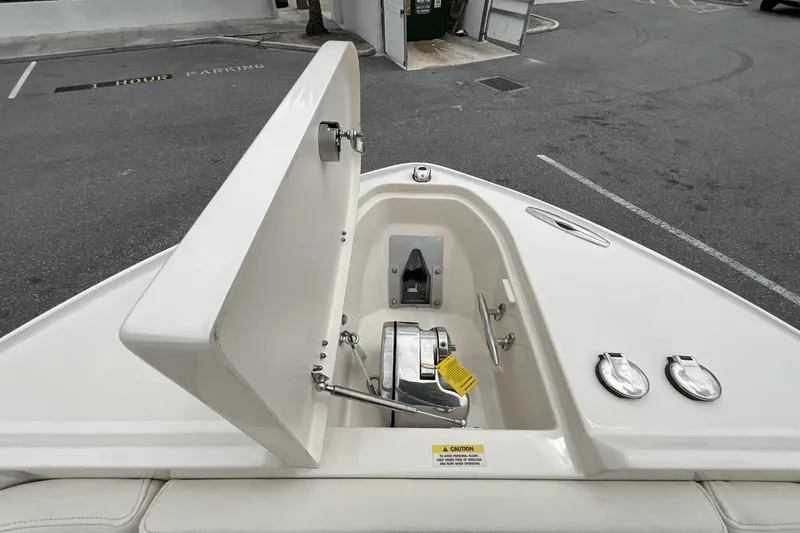 Slide: The Image of 2023 Grady-White Freedom 275 boat anchor compartment open, showing anchor and storage. - 23