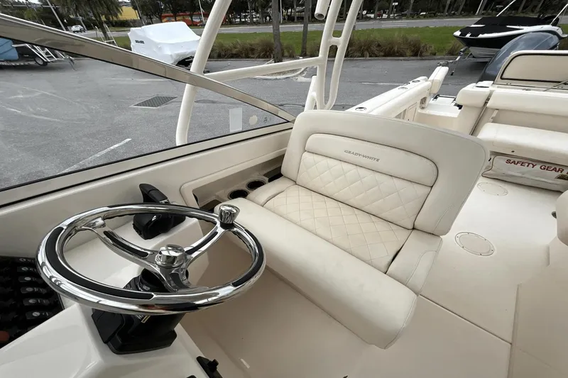 Slide: The Image of 2023 Grady-White Freedom 275 boat interior with steering wheel and cushioned seating. - 8