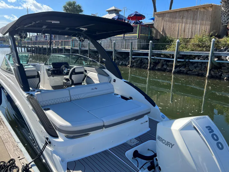 Slide: The Image of 2023 Sea Ray SLX 260 Outboard boat docked, featuring spacious seating and Mercury engine. - 1
