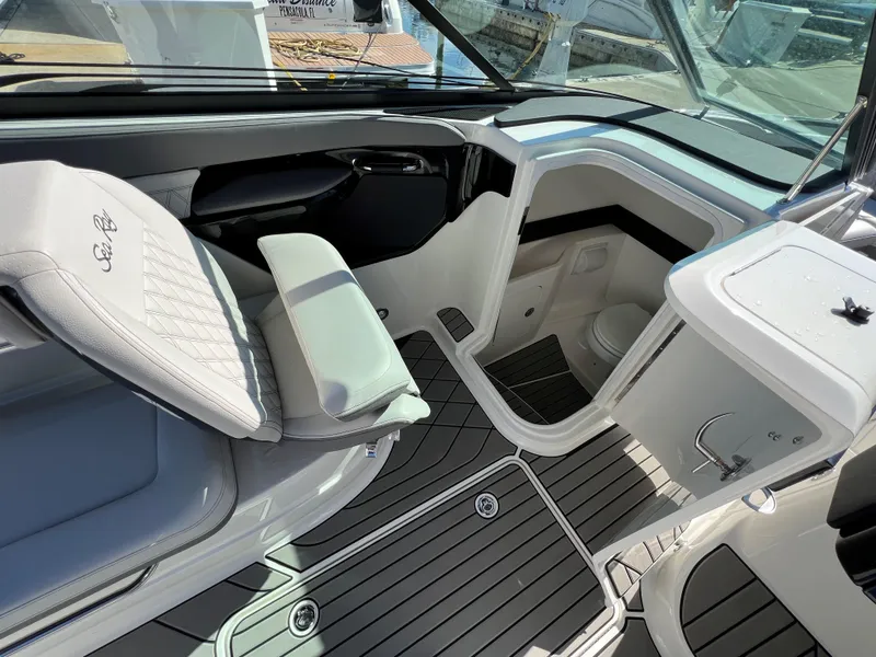 Slide: The Image of 2023 Sea Ray SLX 260 Outboard interior with seating and compact bathroom. - 12